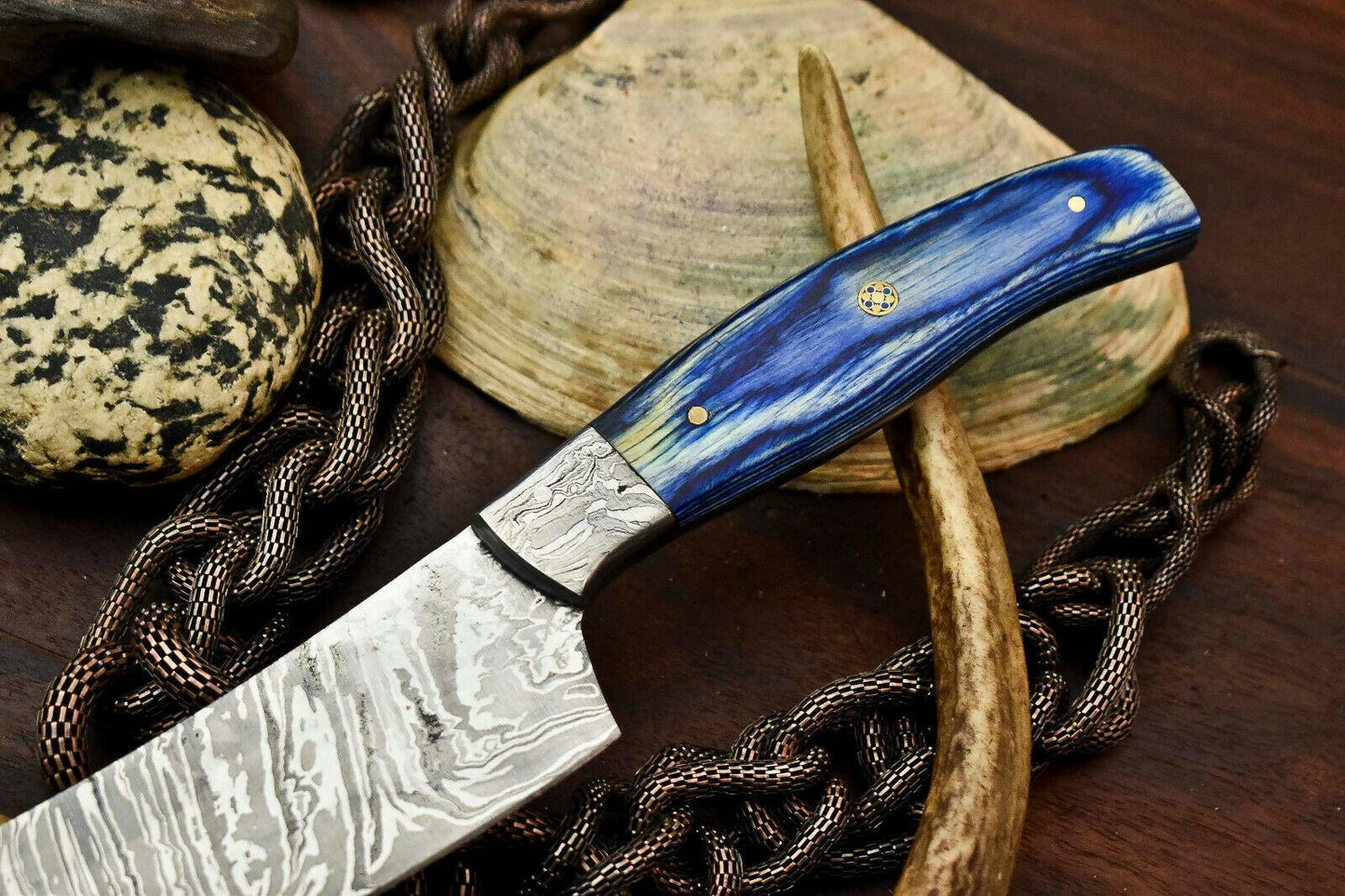 Featuring an etched patterned blade and a vibrant blue swirled handle with pins.