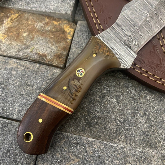 Close up of hand forged Damascus steel blade with upswept skinner tip