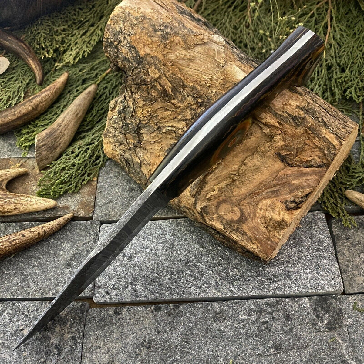 Damascus steel blade closeup showing swirled pattern and drop point