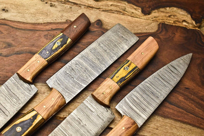 Set of 4 Damascus kitchen knives with striking yellow Pakka wood and rosewood handles displayed flat on a rich wood surface