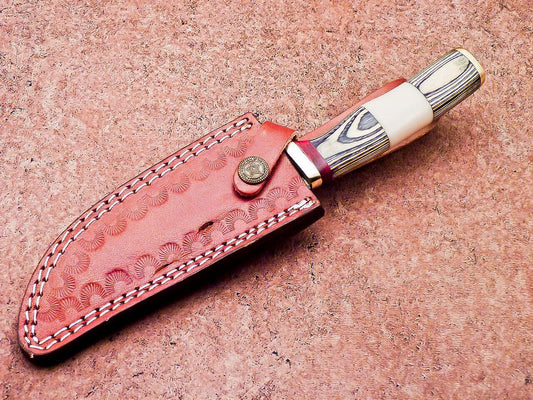 Clip point Damascus hunting blade with a wavy layered pattern