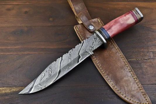 Long Damascus bowie blade with stepped sawback notches on the spine