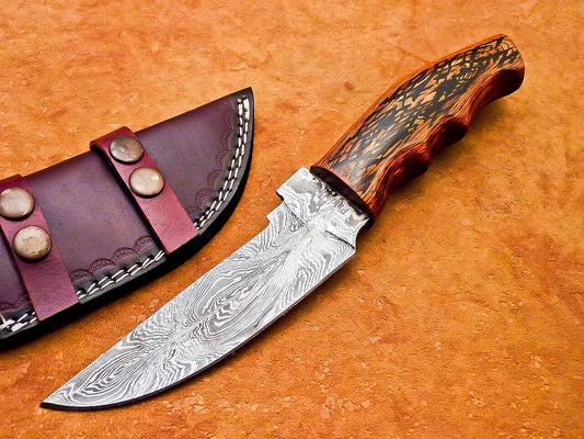 Damascus skinner knife with hardwood handle on orange background
